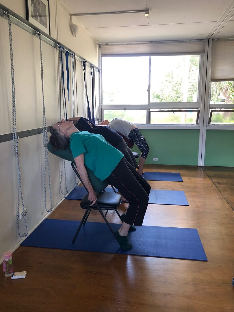 Seniors backbend over chair